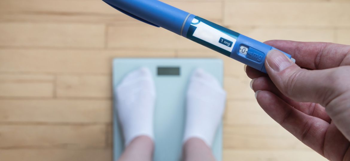 Ozempic Insulin injection pen for diabetics and weight loss. Woman weighs herself and holds Ozempic in her hand.